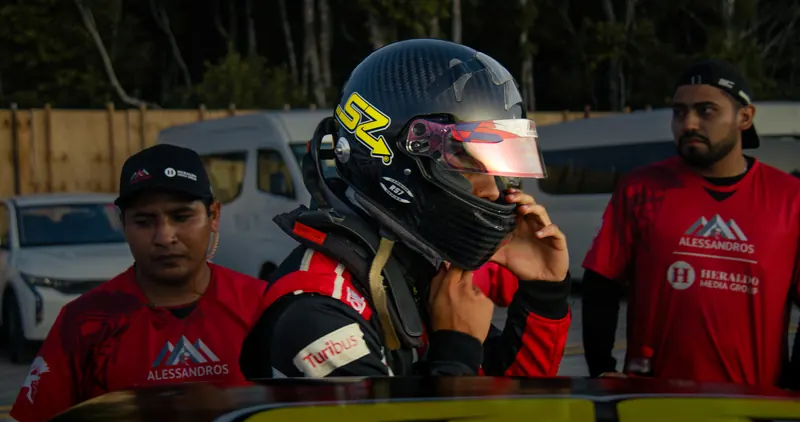 Santiago se pone el casco en el paddock, con su equipo alrededor.